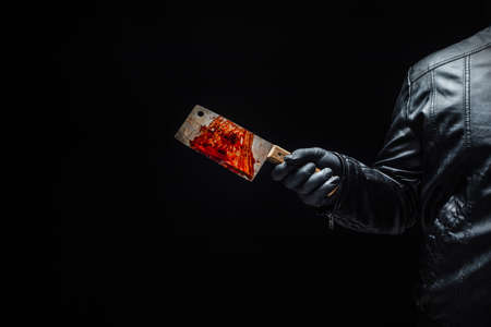 Serial killer's hand with bloody meat cutter and black glovesの写真素材
