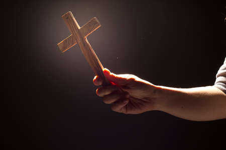 Worship - woman holding cross with qlowの写真素材