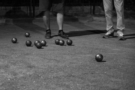 Metal boules on the playing field observed by people. High quality photo