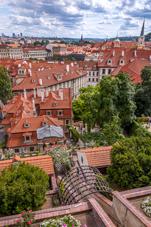 View over red rooftops of Prague from the gardens below Prague Castle in district Lesser Town (Mala Strana) with beautiful clouds. Prague, Czech Republicのeditorial素材