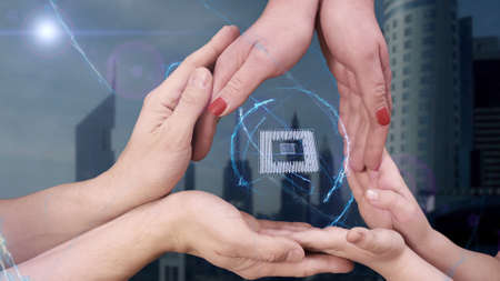 Mens, womens and childrens hands show a hologram 3D chip. The family holds a magical inscription on the background of a modern cityの写真素材