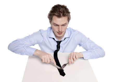 Young man eats his necktie. Studio shot of hungry man, isolated on white.の写真素材