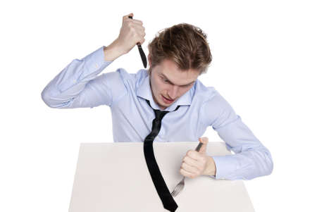 Young man eats his necktie. Studio shot of hungry man, isolated on white.の写真素材