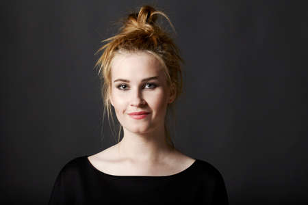 Portrait of attractive young woman on black background.の写真素材