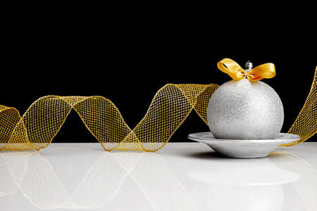 Silver Christmas ball with gold colored bow.の写真素材