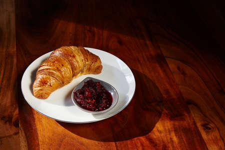Croissants and jam for breakfast on white plate. Copy space.の写真素材