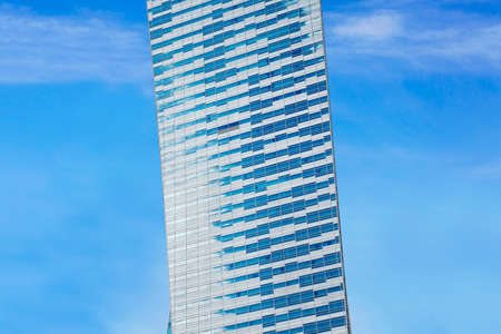 Glass facade of a modern building and sunny blue sky. Copy space.