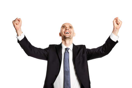 Studio shot of happy young man. He is looking up, gesturing by hands and celebrates victory.の写真素材
