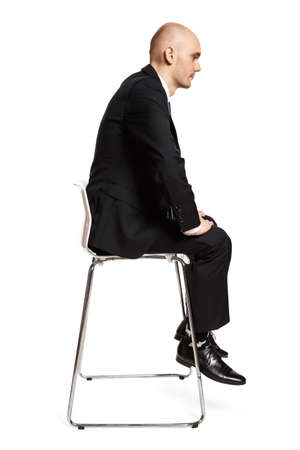 Profile view of young tired office worker sitting on a chair. Studio shot isolated on white background.の写真素材