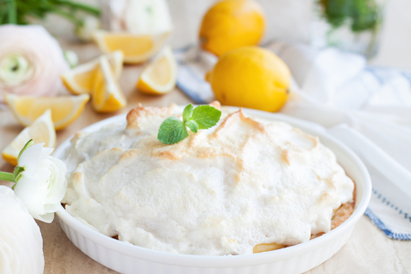 Homemade lemon meringue pie with mint leaves on lihgt stone backroundの写真素材