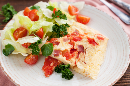 Spicy Omelet with ham, tomatoes, pepper, cheese and herbsの写真素材
