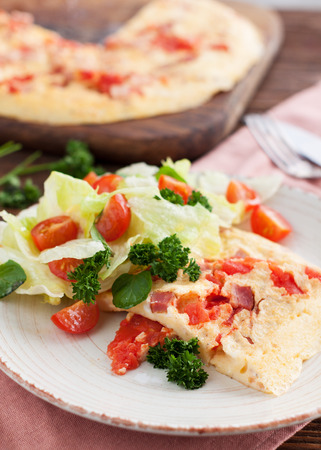 Homemade spicy Omelette with ham, tomatoes, pepper, cheese and herbsの写真素材