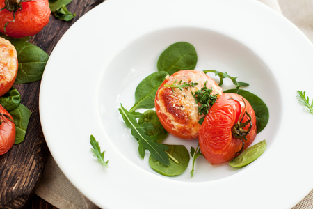 Roasted tomatoes with parmesan cheese, served with arugula and baby spinach leaves. Summer foodの写真素材
