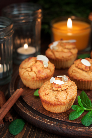 Gluten free pumpkin and carrot muffins decorated with almonds on dark wooden cutting board. Thanksgiving Day dessertの写真素材