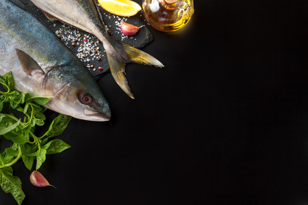 Fresh tuna fish with lemon, oil and spices on black backgroundの写真素材