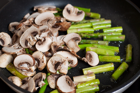 Fresh chopped mushrooms and asparagus in frying pan. Cooking frittataの写真素材