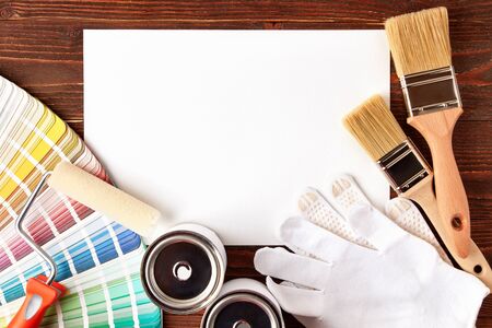Diverse painting tools, brushes, can with paint, color guide palette on wooden table with place for text.の写真素材