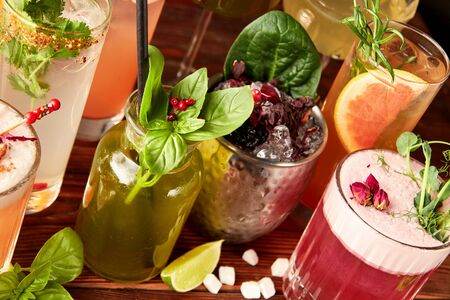 Colorful cocktails in different glasses on wooden tableの写真素材