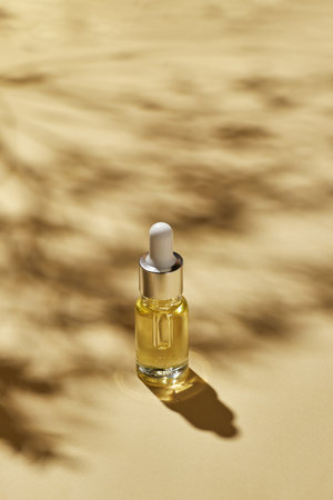 Spa cosmetics, oil for facial massage in glass bottle on background with shadows, minimalism beauty and salon therapy concept.の写真素材
