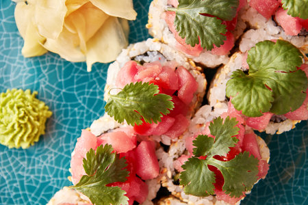 Japanese sushi rolls with tuna decorated with parsley on blue ceramic plate.の写真素材