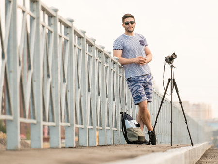 Man with photo camera on tripod taking timelapse photos in the cityの写真素材