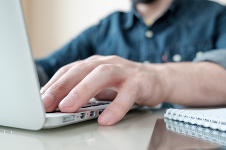 Hands of businessman in home office typing on laptop
