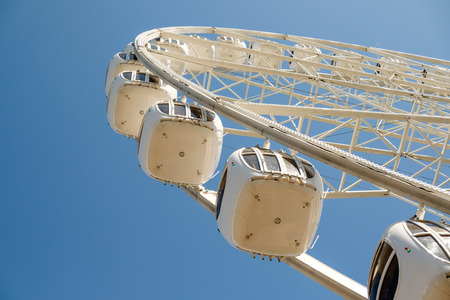 A modern white Ferris wheel against blue sky