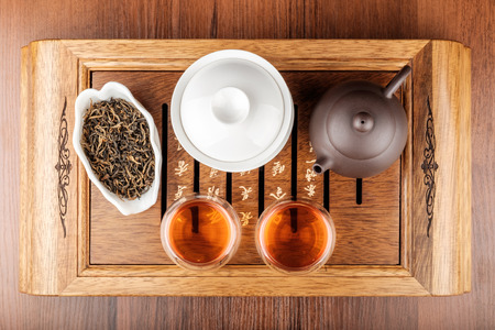 Chinese tea set with glass cups, porcelain brown teapot on wooden deskの写真素材