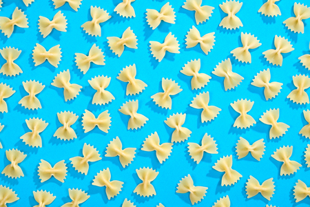 Farfalle pasta random flat lay pattern on blue backgroundの写真素材