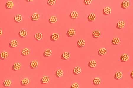 Rotelle pasta random flat lay pattern on red backgroundの写真素材