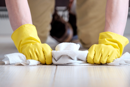Man's hands manually cleaning the floor with white ragの写真素材