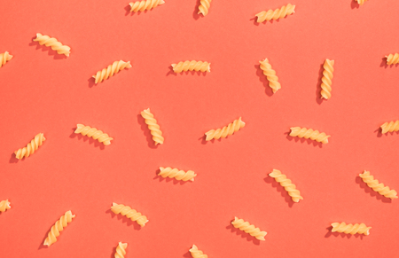 Fusilli pasta random flat lay pattern on red backgroundの写真素材