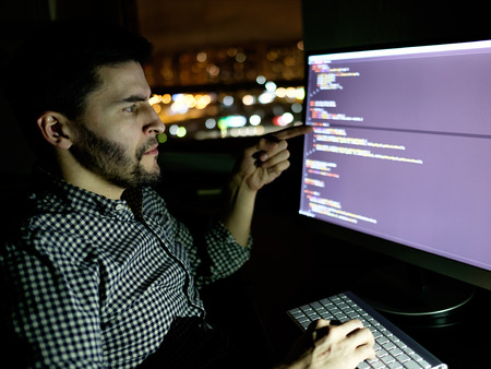 Software developer computer at dark home office. Startup and hard working conceptの写真素材