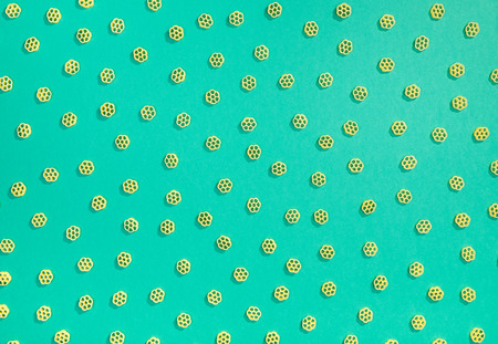 Rotelle pasta random flat lay pattern on green backgroundの写真素材