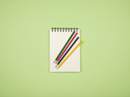 Flat lay style picture of workspace with office supplies on pastel colored background. Top view