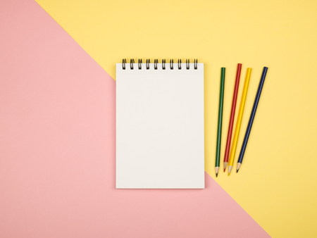 Top view of blank notebook page with colored pencils on table. Flat layの写真素材