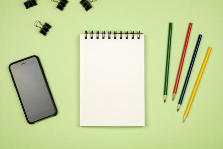 Top view of blank notebook page with colored pencils on table. Flat layの写真素材