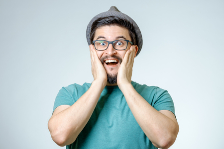Man with shocked, amazed expression isolated on gray backgroundの写真素材