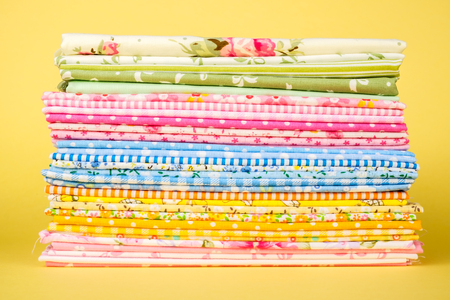 Pile of colorful cloth over colorful background isolatedの写真素材