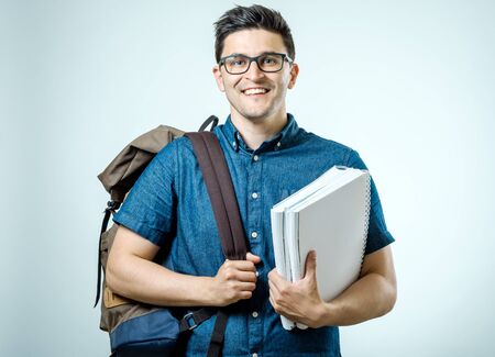 Portrait of young man with backpack isolated on gray backgroundの写真素材