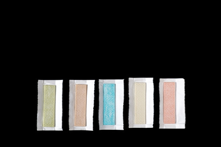 Group of chewing gum plates wrapped in foil on black backgroundの写真素材