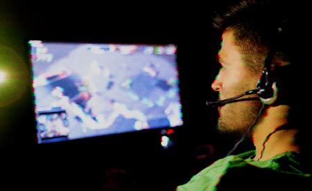 Young man playing computer games online. Digital glitch effect added