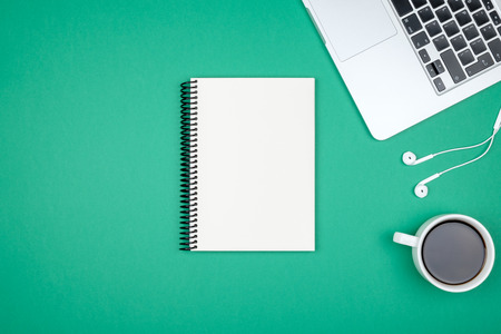 Minimal workplace with laptop and blank notepad on colored background. Top view. Flat layの写真素材