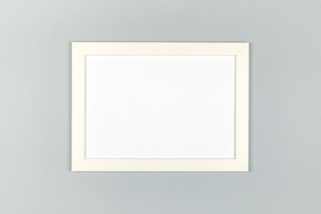 Flat lay pastel colored textured minimalist background with empty picture frame mockupの写真素材