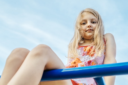 Cheerful little girl on outdoor playground equipmentの写真素材