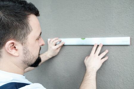 Construction worker using spirit level in a new house