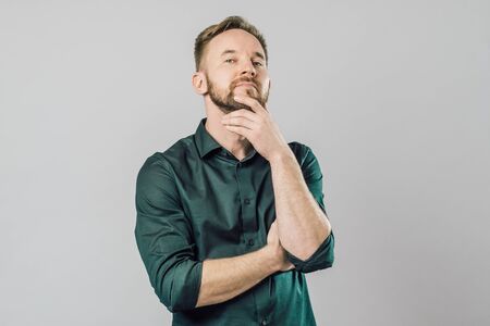Portrait of focused smart with thoughtful determined expression, thinking over grey background