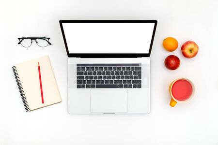 Opened laptop with isolated screen on white desk. Flat lay. Top view