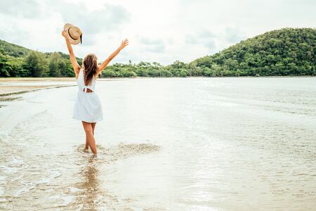 Freedom happy woman with raised arms on the beach at sunny day. Happiness and freedom conceptの写真素材