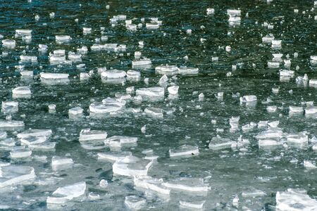 Abstract ice background with cracks on the ice surface. Pattern of transparent shiny ice
